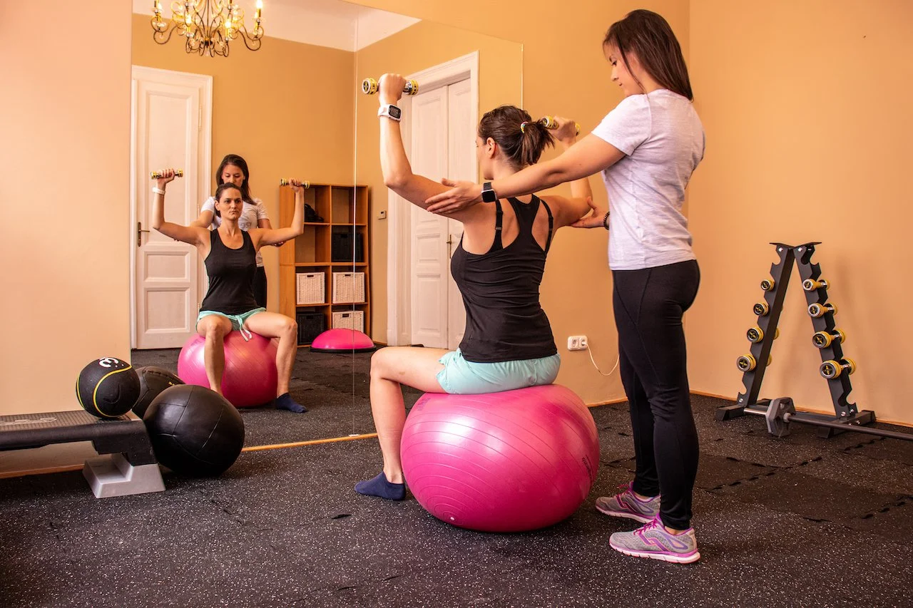 female personal trainer with client doing exercise